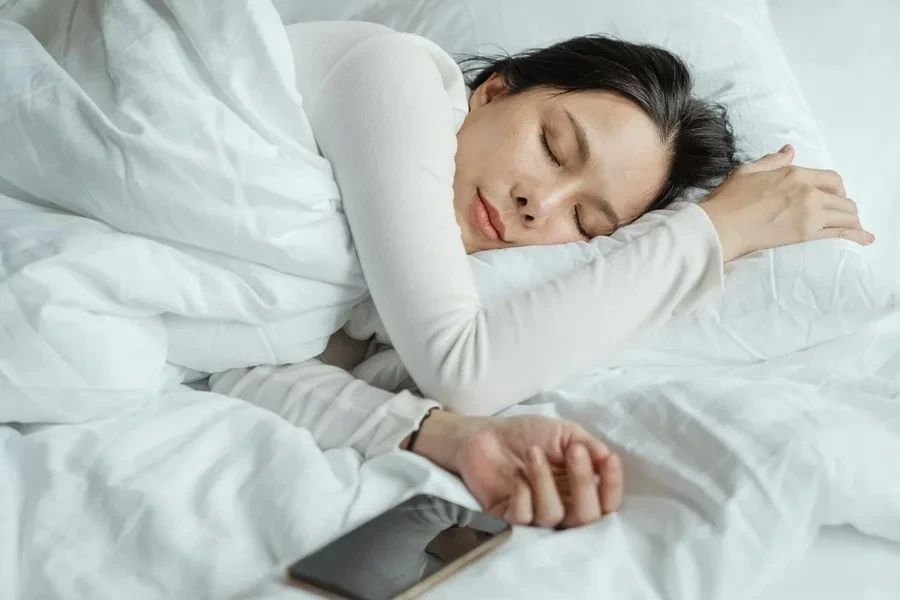 A woman sleeping with a smartphone kept beside her