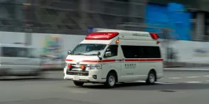 an ambulance driving down a street next to a building