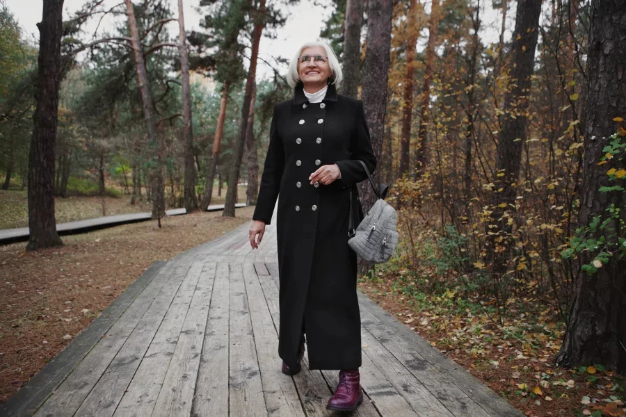 Happy older woman in a long black, double-breasted coat