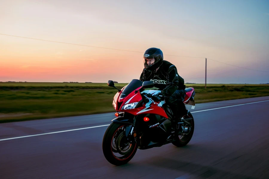 man riding sports motorcycle on road