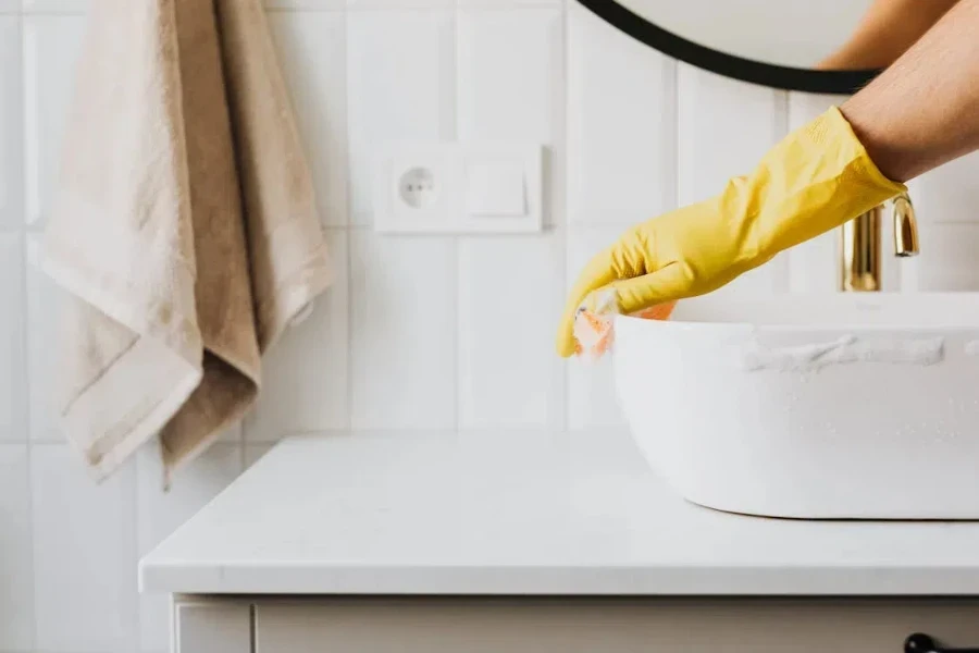 person cleaning a bathroom sink