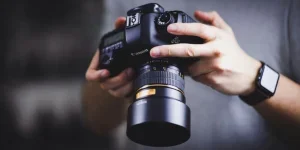 person holding Canon DSLR camera