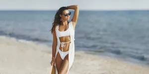 Woman embodies Italian Riviera chic in a white bikini, sunglasses