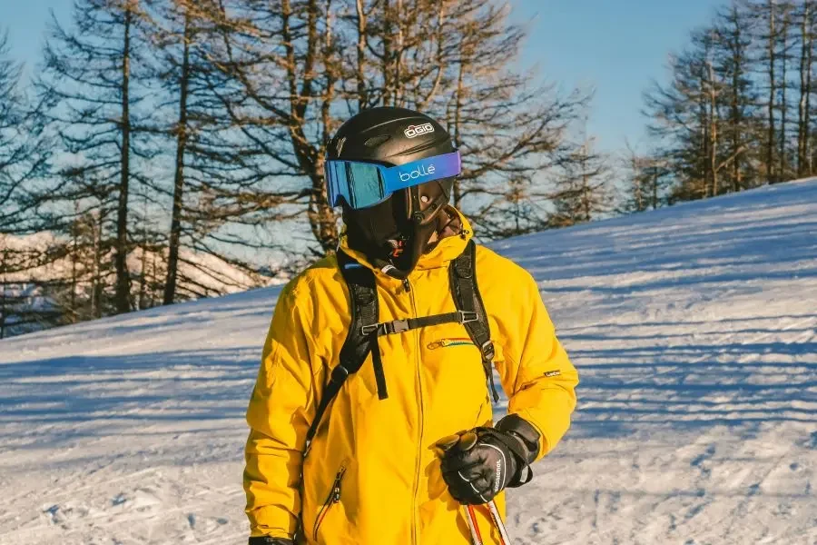 a man in a yellow jacket is standing in the snow