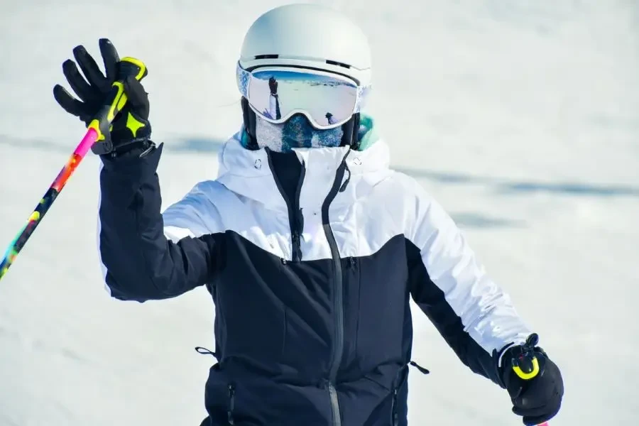 Close up skier in cold day in winter ski resort pose wear warm clothes, scarf, goggles, helmet , warm jacket