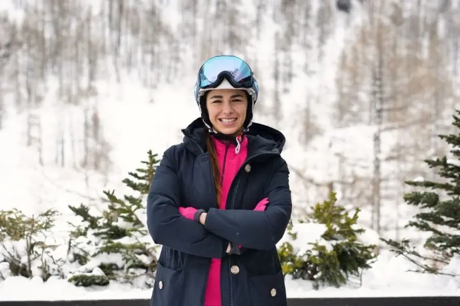 Close-up of a smiling skier on a vacation in the mountains, peering over the ski slopes