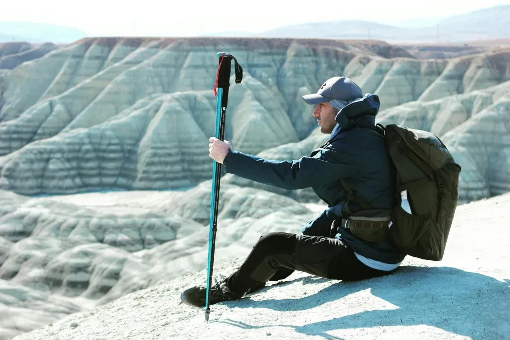 Man hiking sits on a cliff in Nallıhan, Ankara, Türkiye, enjoying the stunning barren landscape