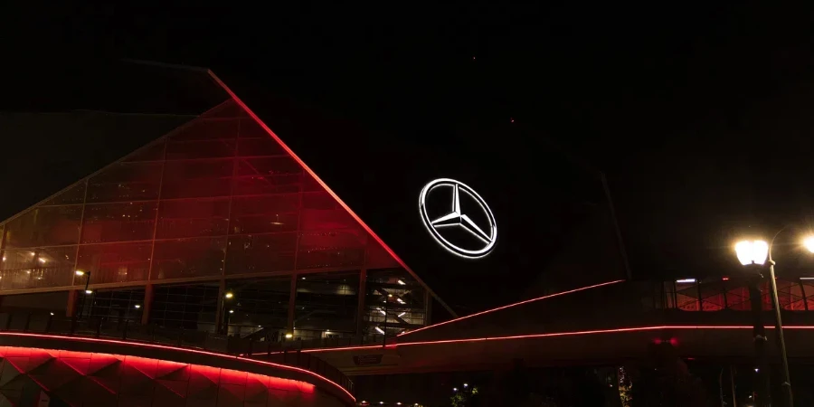 A Mercedes Stadium is lit up in red on a building