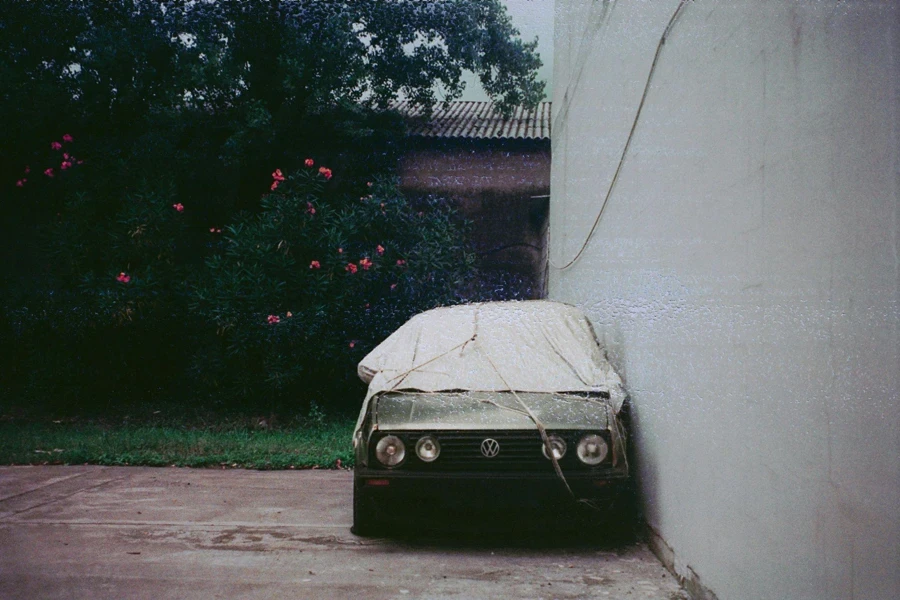 A Volkswagen Golf II with a Cover Parked by the Wall