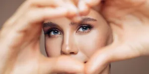 A beautiful lady showing love sign in front of her eyes