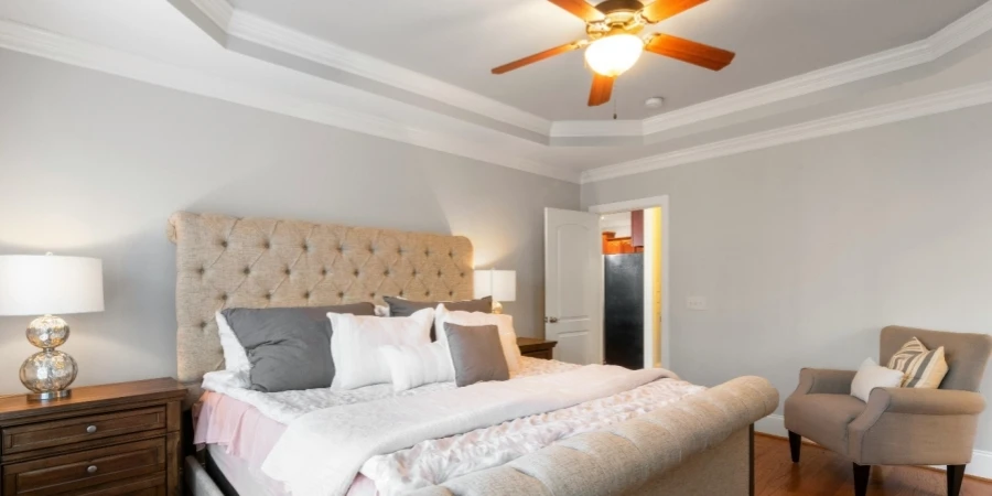 A bedroom with a large bed and a ceiling fan