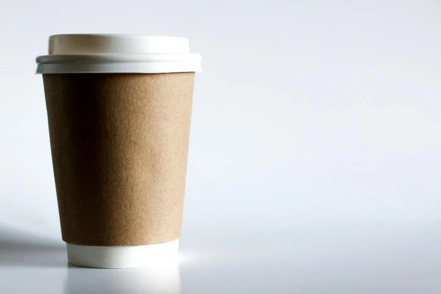 A brown paper cup with a white lid