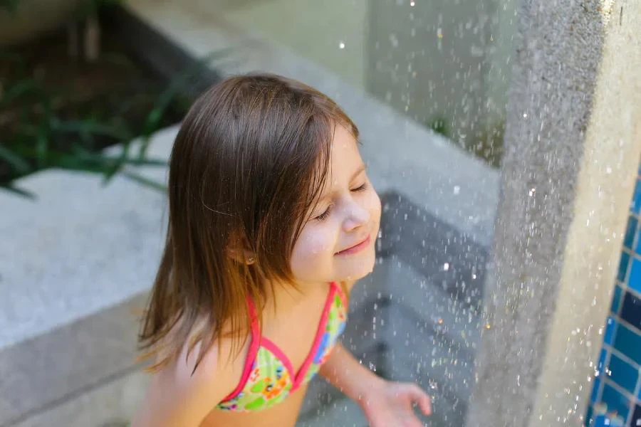 A child using a stand-alone outdoor shower