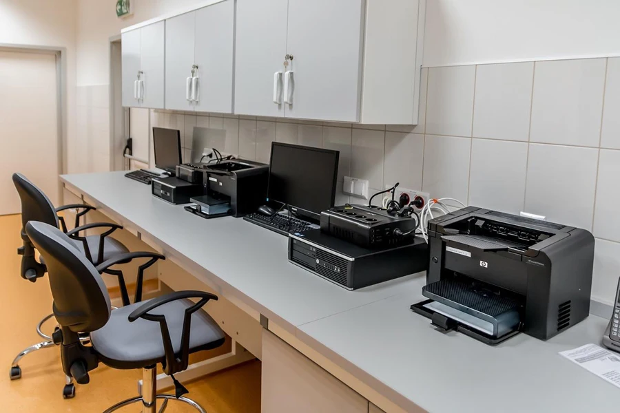 A desk with computers and a printer