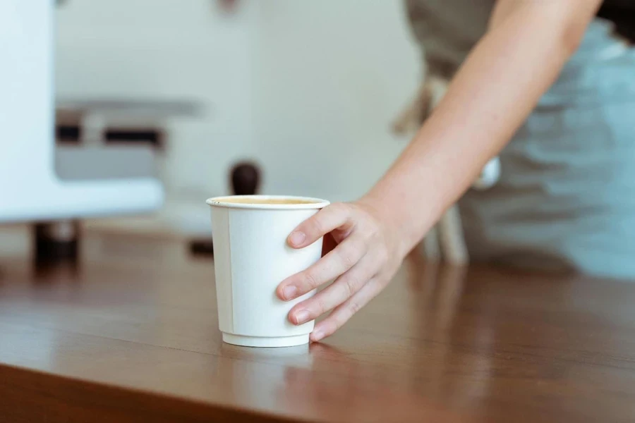 A hand holding a cup of coffee