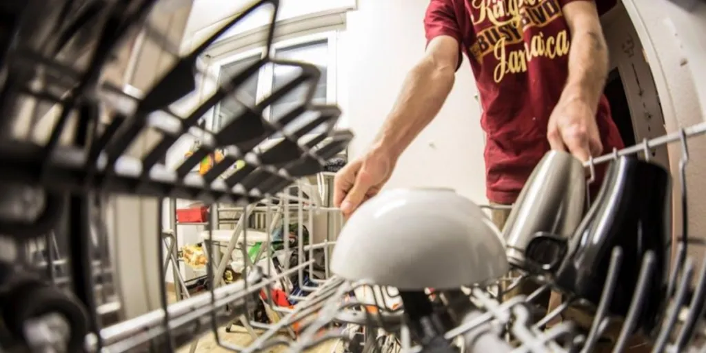 A man pulling a dishwasher rack