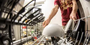 A man pulling a dishwasher rack