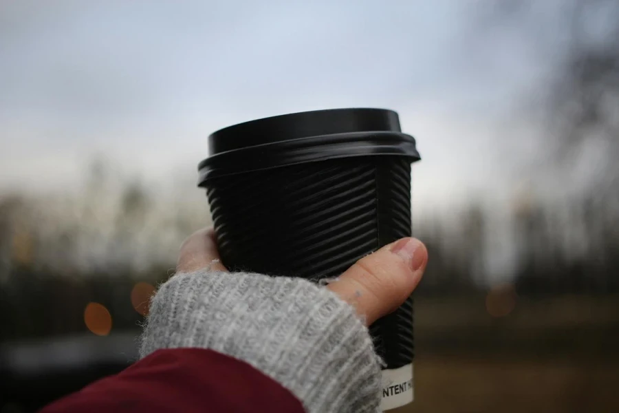 A person holding a black cup