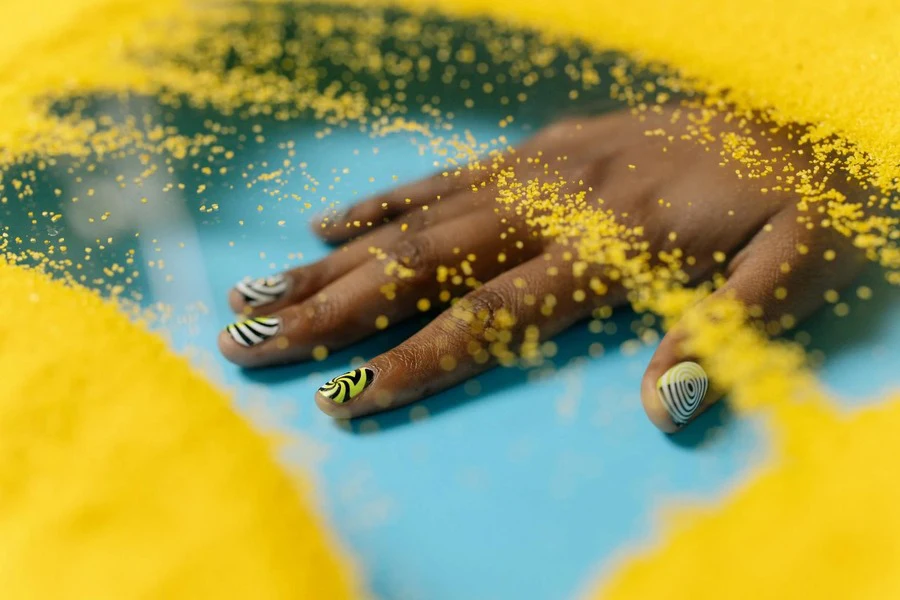 A person’s hands with animal-printed nail colors