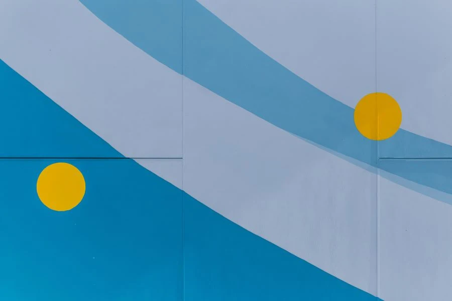 A wall painted in shades of blue and gray with yellow dots