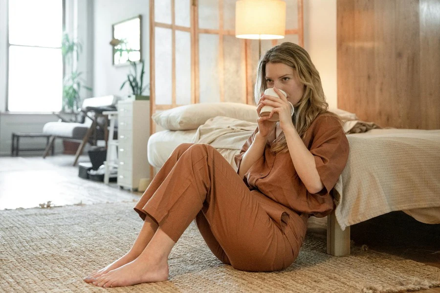 A woman with blonde hair sipping from a cup