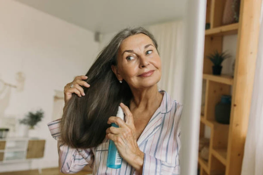 Aging Woman Using Moisturizing Spray for Hair