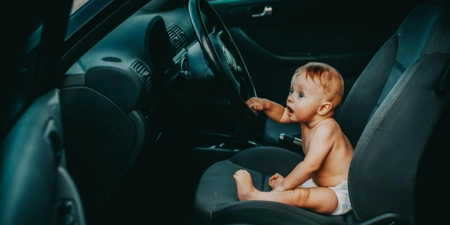 Baby Sitting by Steering Wheel in Car