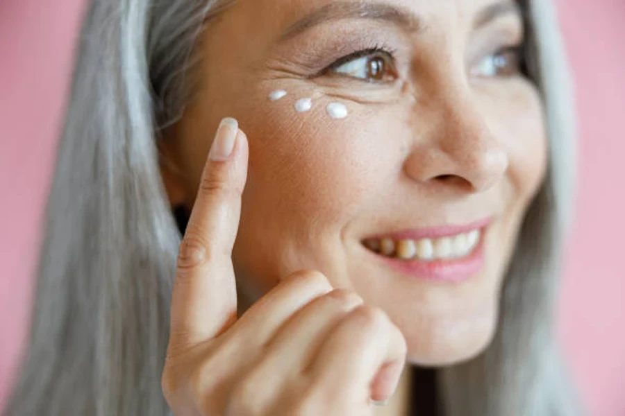 Beautiful Mature Asian Lady Applies Antiaging Cream Under Eye