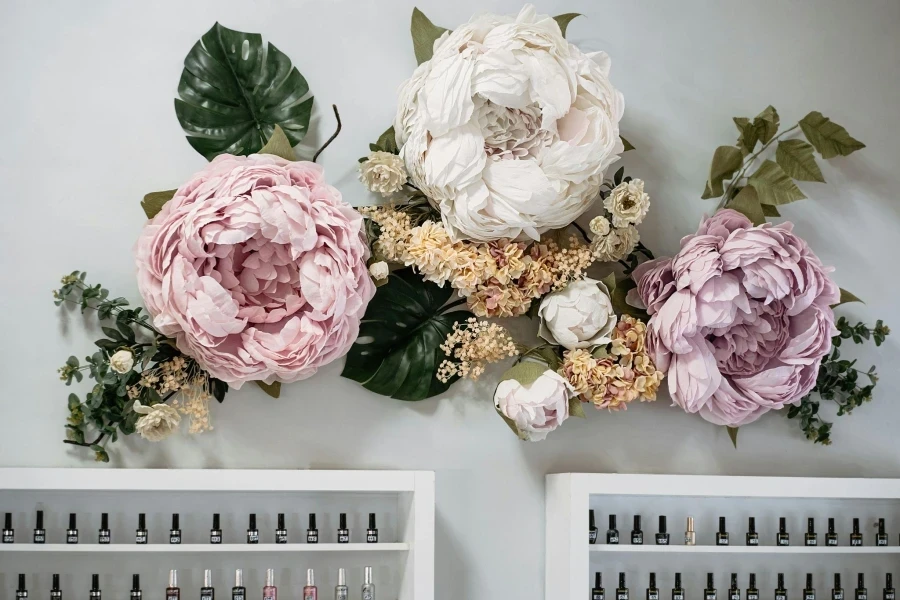 Big Artificial Flowers Decoration Hung on the Wall Above the Nail Polish Shelves