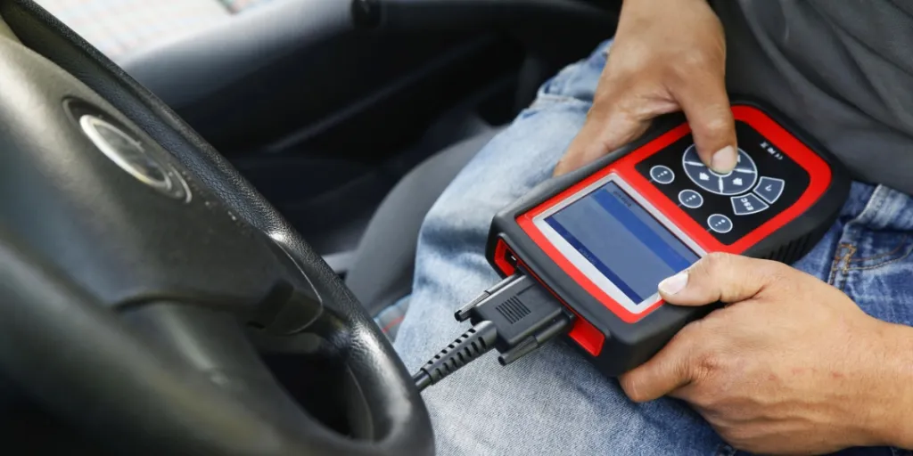 Car mechanic using a car diagnostic tool