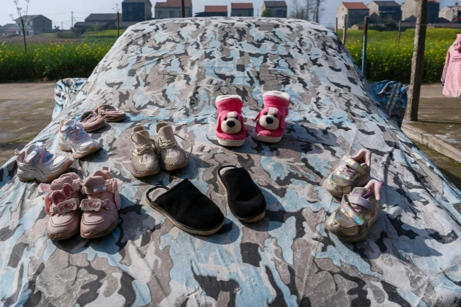 Sapatos e chinelos infantis no capô do carro em uma capa