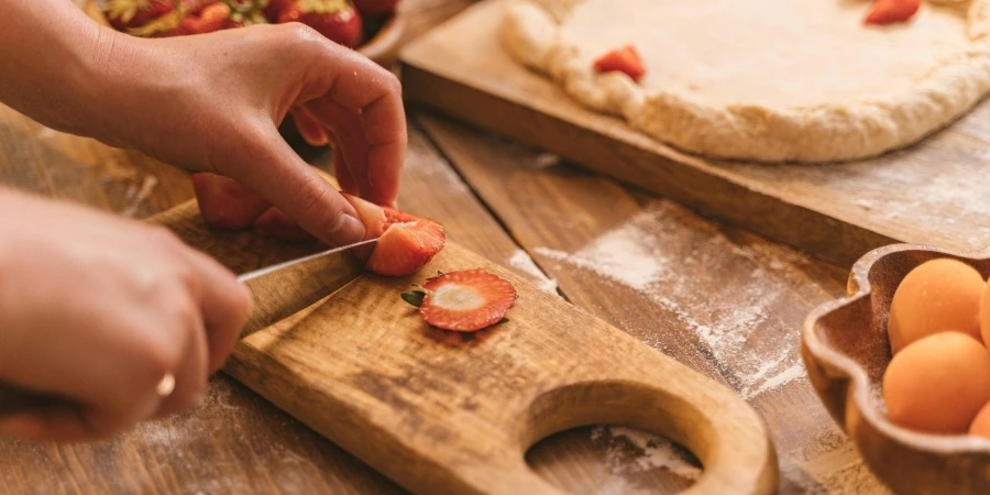 Close-Up Photo of a Person Slicing a Strawberry