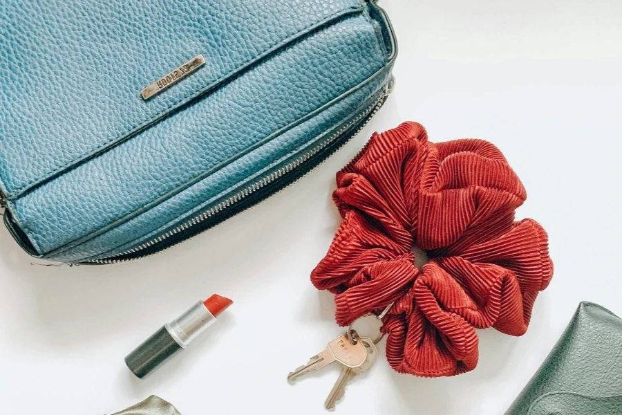 Corduroy hair scrunchie next to blue leather handbag