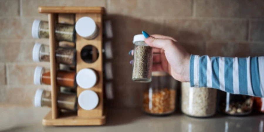 Cropped Hand Holding Jar of Spices on Kitchen Counter