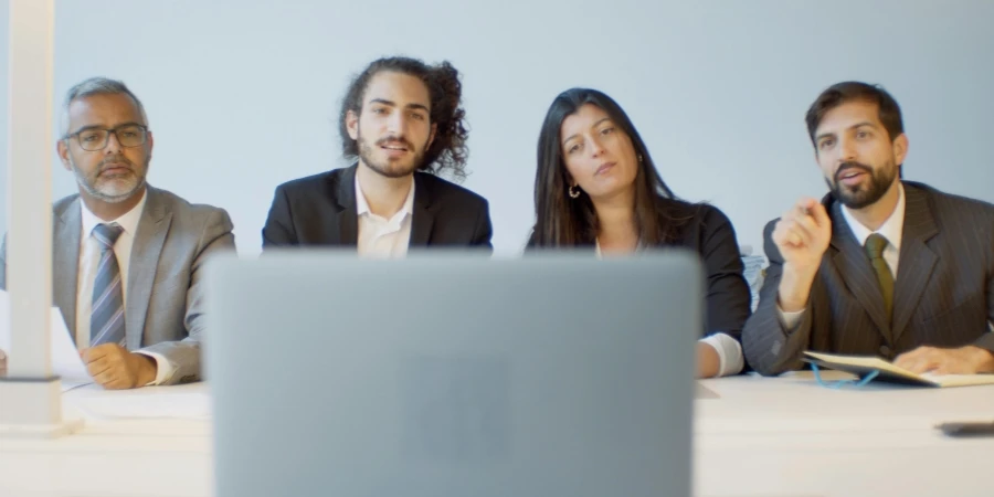 Diverse team of professionals in a meeting discussing with focus on video conferencing setup