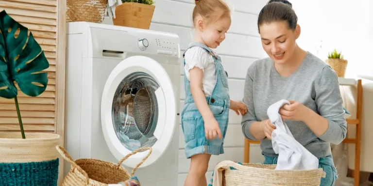 Familia lavando ropa frente a una lavadora de carga frontal