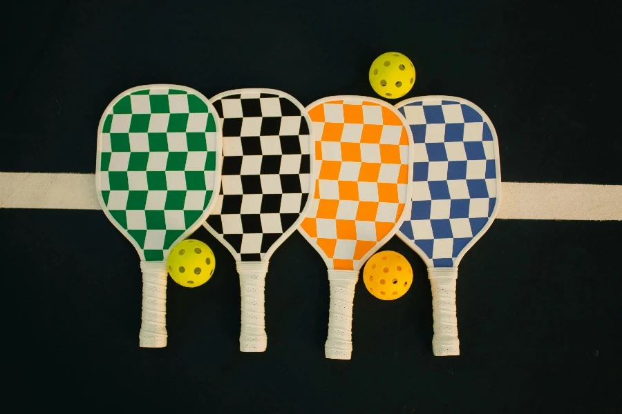 Four checkerboard-patterned pickleball paddles