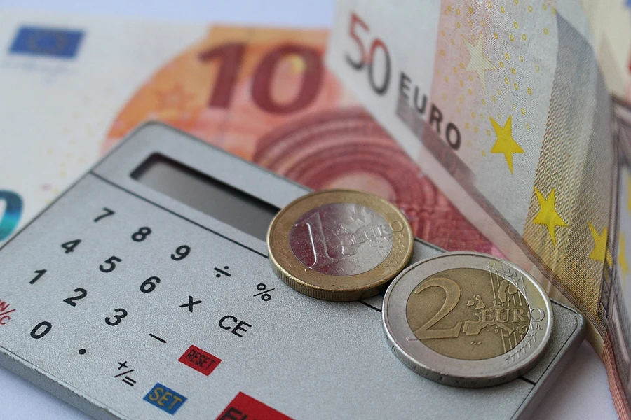 Image of a calculator, coins and paper currency