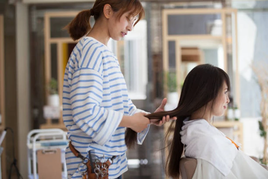 Japanese woman styling hair for young woman in salon