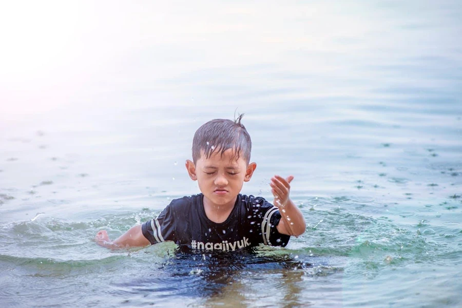 Kid wearing a swim shirt in the water