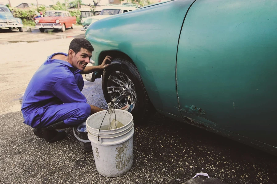 Man Cleaning the Tire of a Car