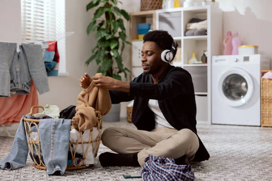 Man Folds Clean Clothes Sorts Laundry Before Putting It in Washing Machine