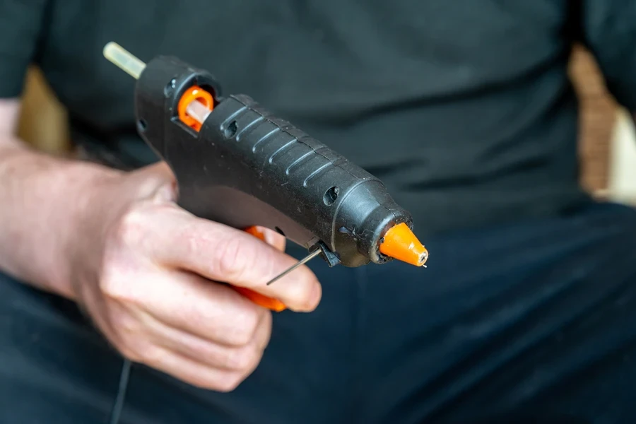 Man holding a hot glue gun