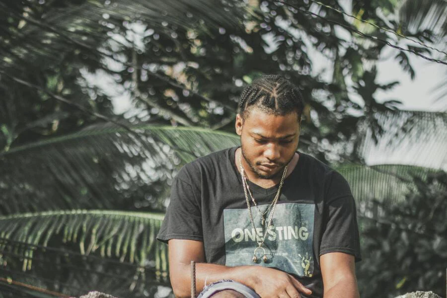 Man in black t-shirt wearing pop smoke braids