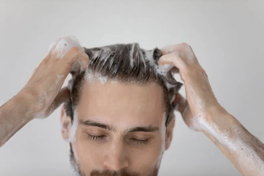 Man using scalp cleanse shampoo on short hair in shower