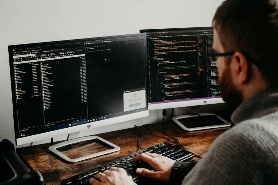 Man working on computers coding