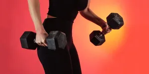 Person Dressed In Black Holds Two Weights In Each Hand