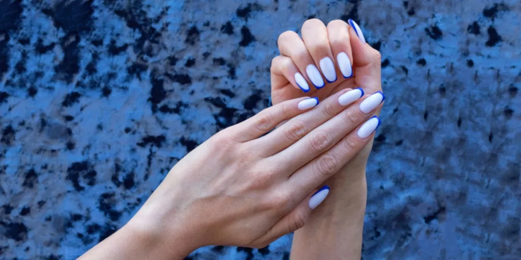 Person showing off white and blue acrylic nails