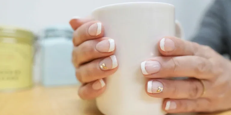 Человек с французским маникюром держит чашку кофе