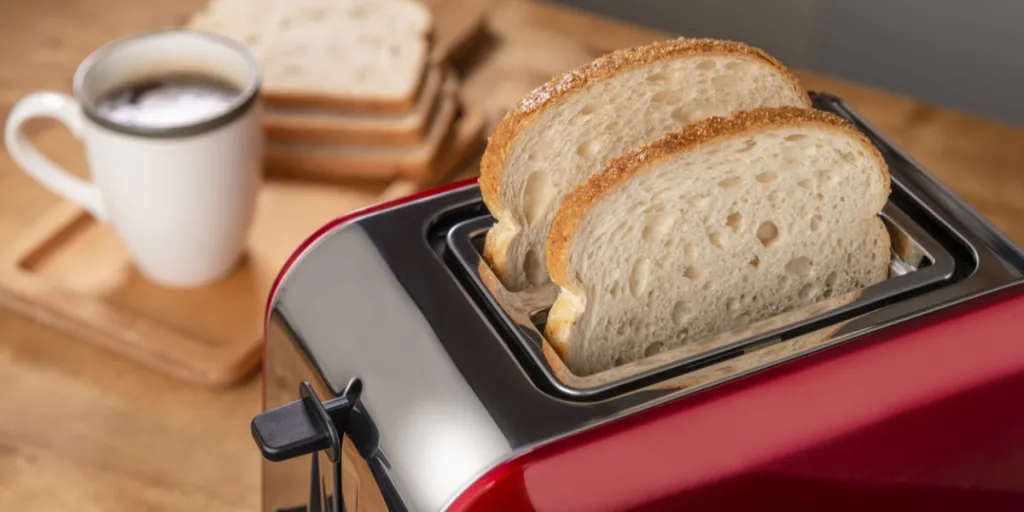 Red toaster and cup of coffee on kitchen table